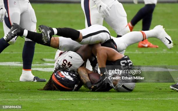 Running back Devontae Booker of the Las Vegas Raiders is tackled by inside linebacker A.J. Johnson of the Denver Broncos in the first half of their...