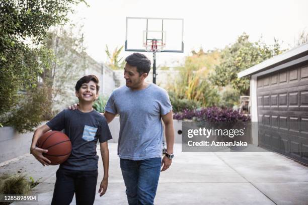 father and son walking back inside after playing basketball outdoors - drive ball sports stock pictures, royalty-free photos & images