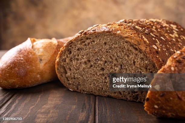 food background with assortment of baked bread and buns on wooden table. healty eating concept. gluten free diet. selective focus - celiac disease stock pictures, royalty-free photos & images