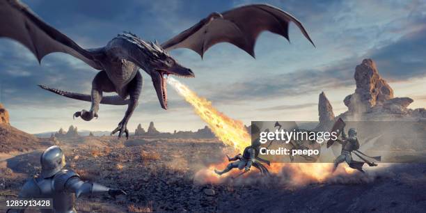 fire breathing dragon flying low and attacking knights in desert - dragão imagens e fotografias de stock