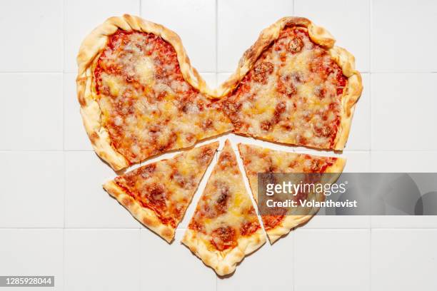 heart shaped pizza margherita with pepperoni hearts on white tiles background - heart shape pizza stock pictures, royalty-free photos & images
