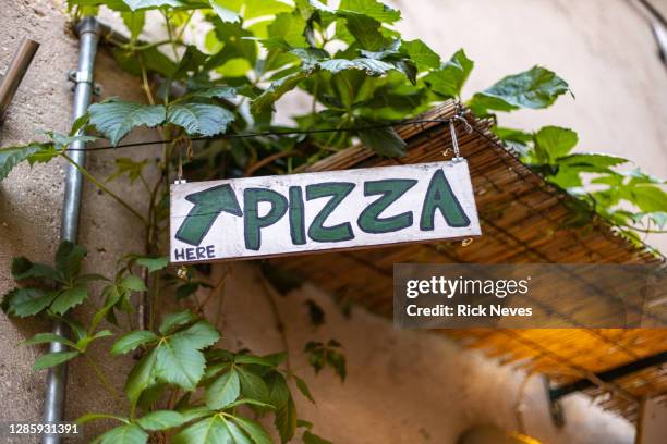 pizza sign in restaurante in malcesine city - pizza italy restuarant stockfoto's en -beelden