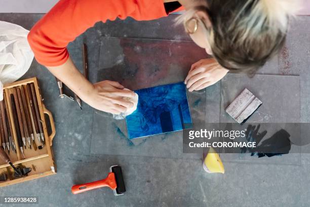 woman putting ink on some metallic plates - stock photo - intaglio 個照片及圖片檔
