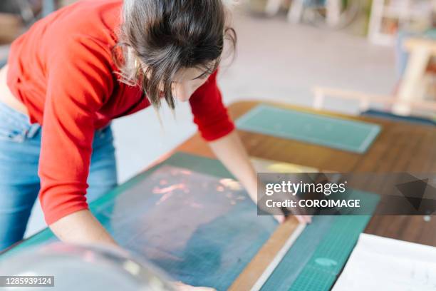 young woman taking measurements in an intaglio workshop - stock photo - intaglio stock pictures, royalty-free photos & images