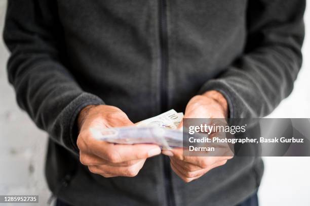 a man holding five and ten pound notes - british pound sterling stock-fotos und bilder