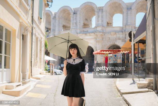 beautiful chinese woman in black retro style dress, traveling in arles city - arles stock pictures, royalty-free photos & images