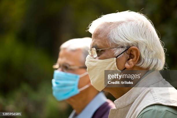 two senior men wearing protective face mask - india covid stock pictures, royalty-free photos & images
