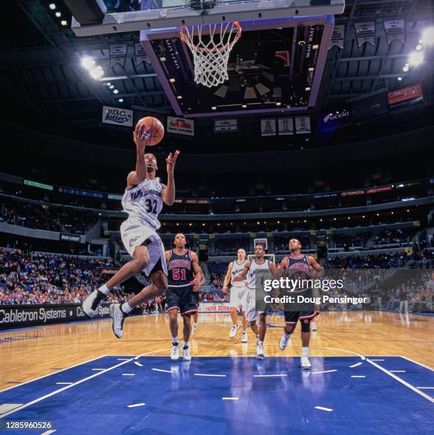 Richard Hamilton, Shooting Guard for the Washington Wizards drives for the basket as Michael Ruffin and B.J. Armstrong of the Chicago Bulls and...