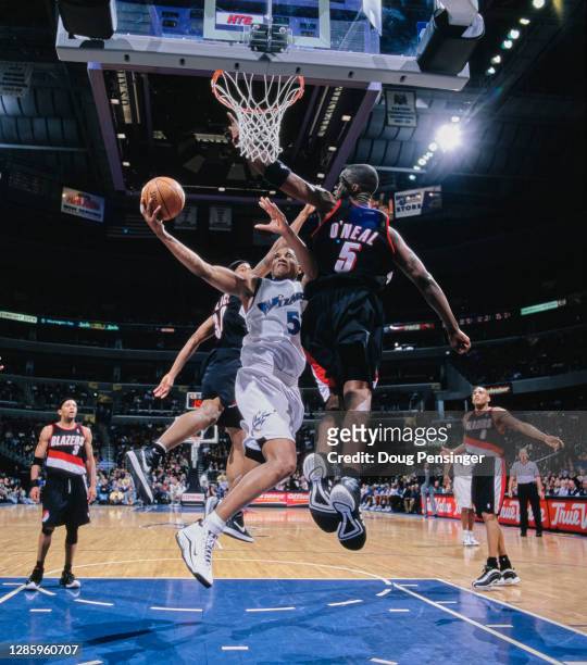 Juwan Howard, Power Forward for the Washington Wizards makes a one handed lay up for the basket as Jermaine O'Neal and Rasheed Wallace of the...