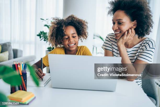 moeder en dochter die online thuis bestuderen. - young girls homework stockfoto's en -beelden