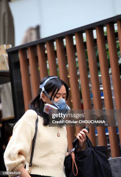 Jeune femme hongkongaise avec un masque de protection anti-gaz et produits toxiques pour se protéger du virus Covid-19 dans le quartier touristique...