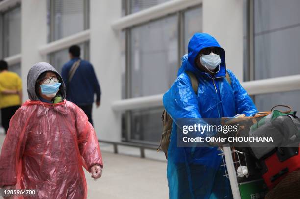 Passagers arrivant d'un vol à l'aéroport International de Hong-Kong, portant masques, lunettes, gants et ccirés de protection contre le Covid-19 le...