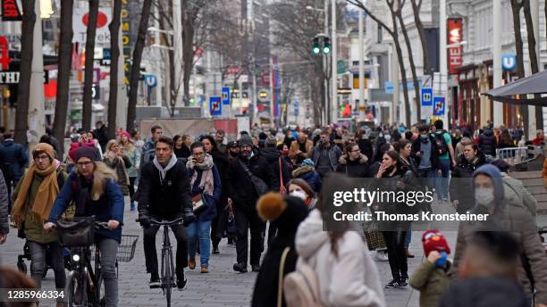 People walk along the popular Mariahilferstrasse pedestrian shopping zone the day before a strict nationwide lockdown is to go into effect on...