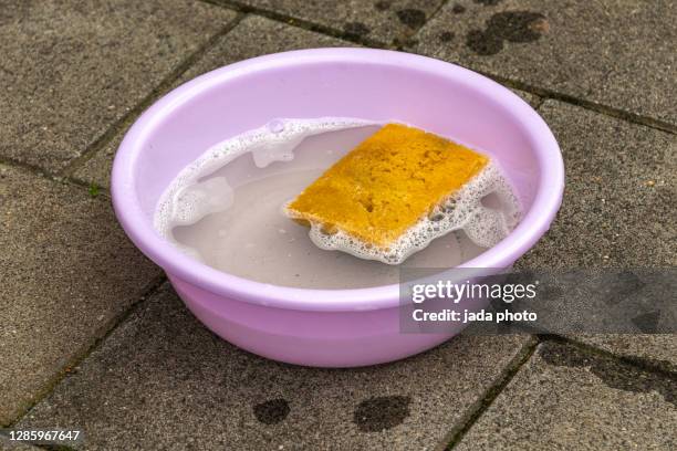 purple plastic round tub filled with soapy water - esponja equipamento de limpeza imagens e fotografias de stock
