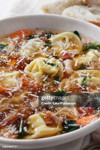 italian white bean, pancetta and tortellini soup in broth - pancetta stock pictures, royalty-free photos & images