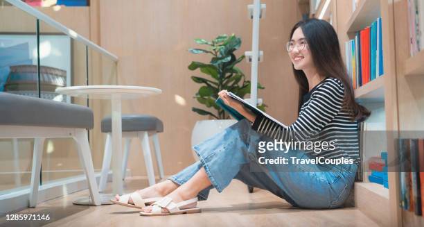 learning and education concept. back to school education knowledge college university concept. beautiful female college student holding her books smiling happily standing in library. - beautiful college girls stock pictures, royalty-free photos & images