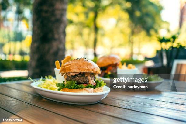 tasty hamburger with french fries on wooden table - bbq sandwich foto e immagini stock