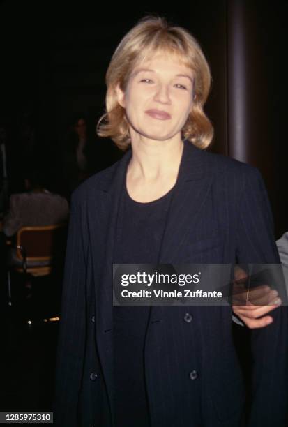 American actress Ellen Barkin wearing a black crew neck top beneath a black pinstripe jacket, location unknown, 1994.