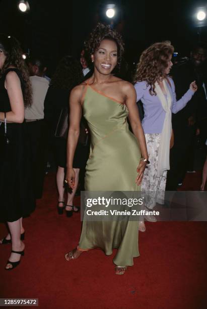 American actress Angela Bassett wearing a green asymmetric evening gown attends the premiere of 'How Stella Got Her Groove Back' held at Mann's...