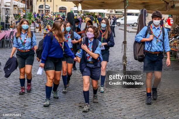 een groep verkenners met medische maskergang in campo de fiori vierkant in rome - scouts stockfoto's en -beelden