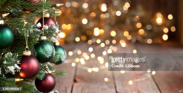 albero di natale, ornamenti rossi e verdi contro uno sfondo luci sfocalizzato - decorazione festiva foto e immagini stock