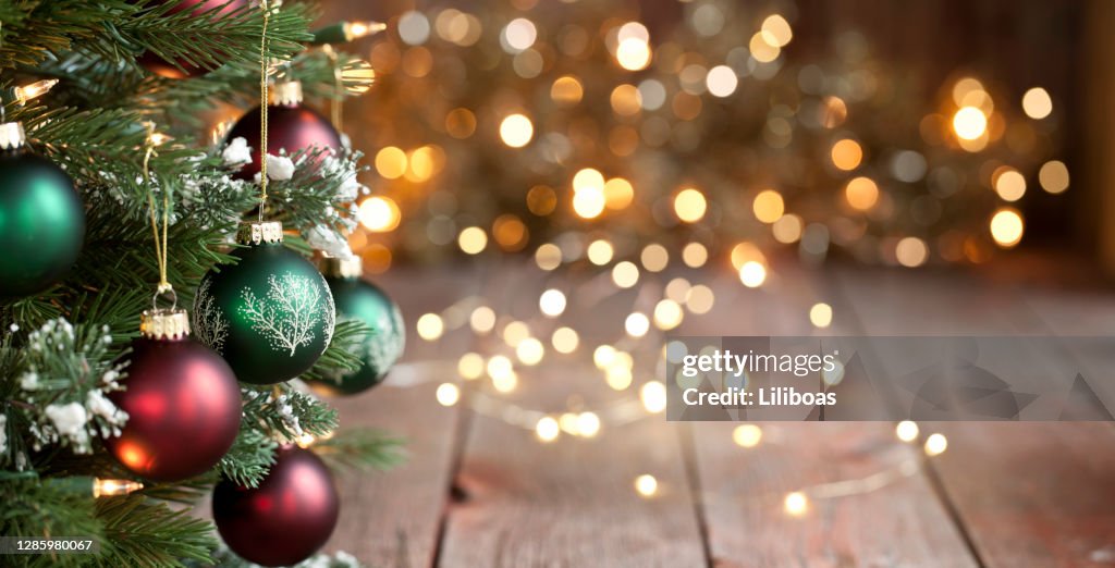 Julgran, röda och gröna ornament mot en Defocused Lights Bakgrund