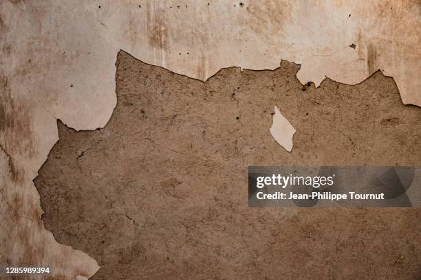 cracked paint on a damaged adobe wall, middle east - adobe texture stockfoto's en -beelden