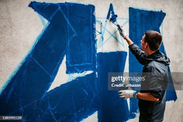 graffiti de peinture d’homme sur le mur - modern art photos et images de collection