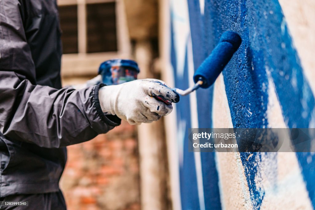 Painting graffiti with paint scroller