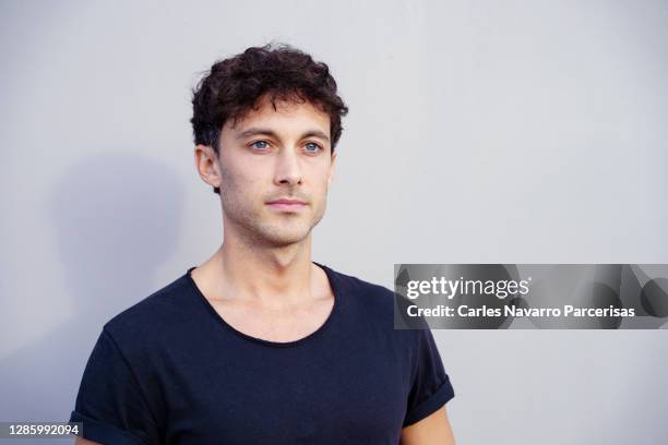 portrait of a young man in casual clothes with thoughtful expression in front of a white background - young men talking stock pictures, royalty-free photos & images