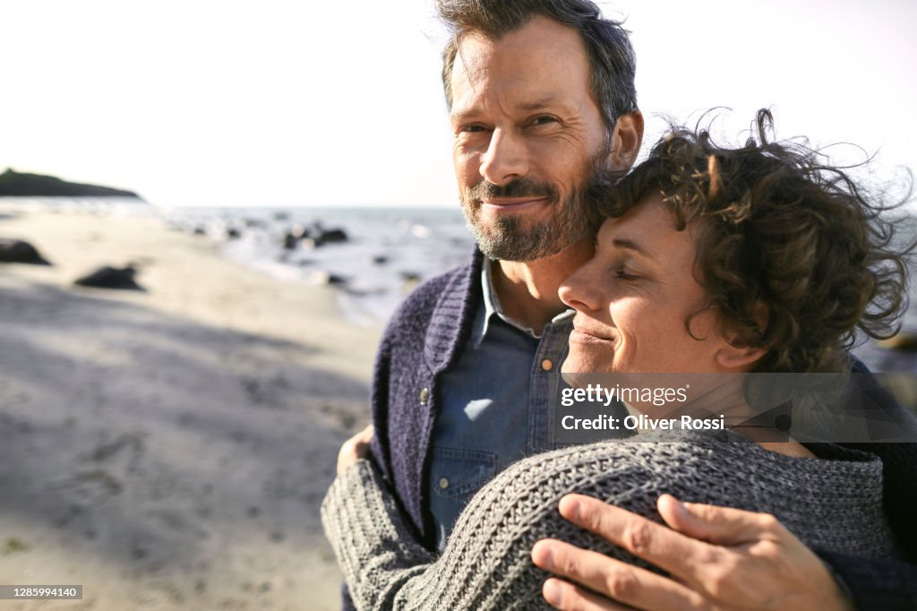 Portrait of smiling mature couple embracing on the beach