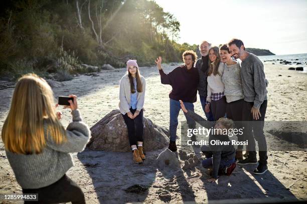 girl taking smartphone picture of family and friends on the beach - young teen girl beach foto e immagini stock