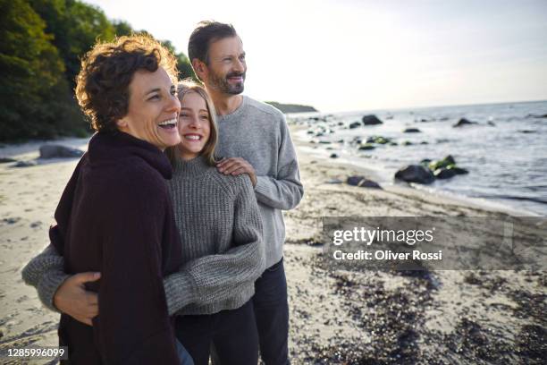 happy family standing on the beach - two parents stock-fotos und bilder