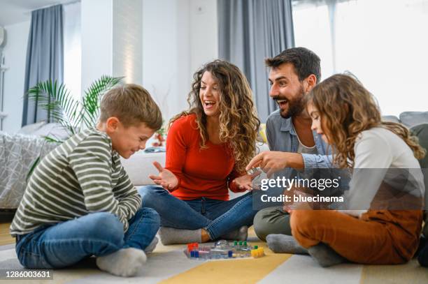 vrolijke ouders die bordspel met hun kinderen spelen. - game six stockfoto's en -beelden