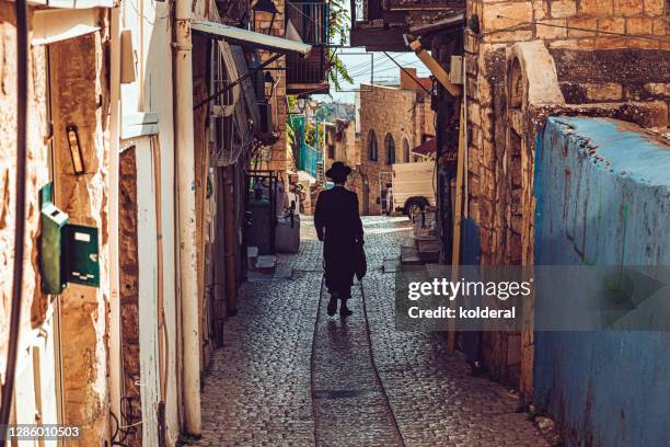 hasid walking in historic neighborhood - safed stock pictures, royalty-free photos & images