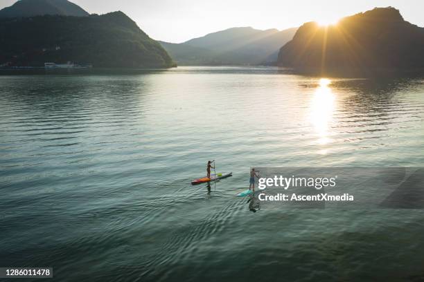 日落時分，兩個槳板在湖上拍攝的空中視角 - paddleboard 個照片及圖片檔