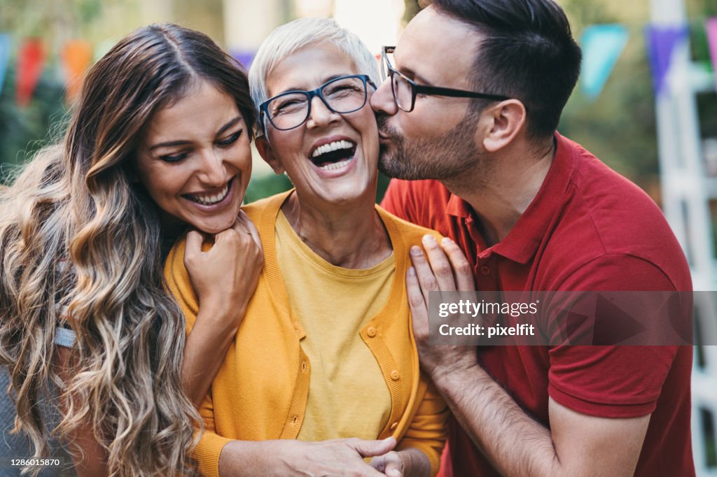 Adult son kissing his mother no the cheek