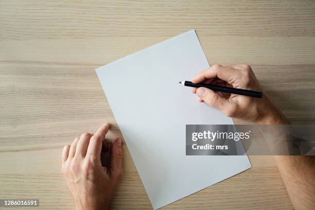 hand holding pencil and blank sheet of paper - crayon photos et images de collection
