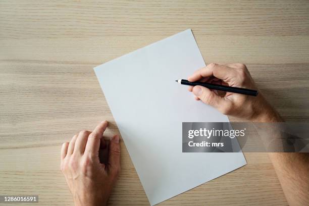 hand holding pencil and blank sheet of paper - hand writing foto e immagini stock