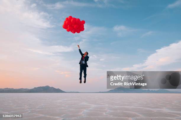 homme d’affaires volant avec des ballons - fly photos et images de collection