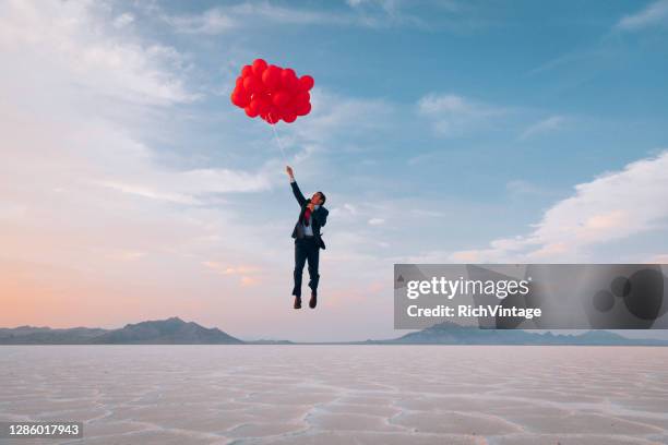 businessman flying with balloons - business humor stock pictures, royalty-free photos & images