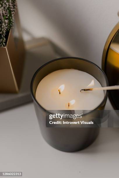 close-up of a candle lighted up with a match - candela attrezzatura per illuminazione foto e immagini stock