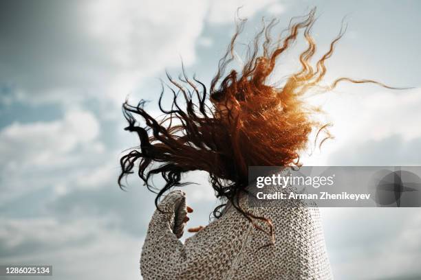 redhead woman with wind blown hair - despeinado fotografías e imágenes de stock