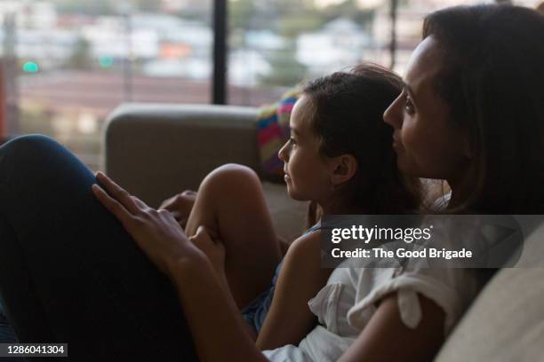mother and daughter sitting on sofa watching tv - couch close up stock pictures, royalty-free photos & images