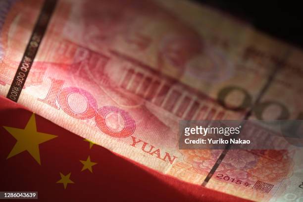 In this photo illustration, an one hundred Chinese yuan banknote is pictured above an image of a Chinese flag on November 14, 2020 in Katwijk,...