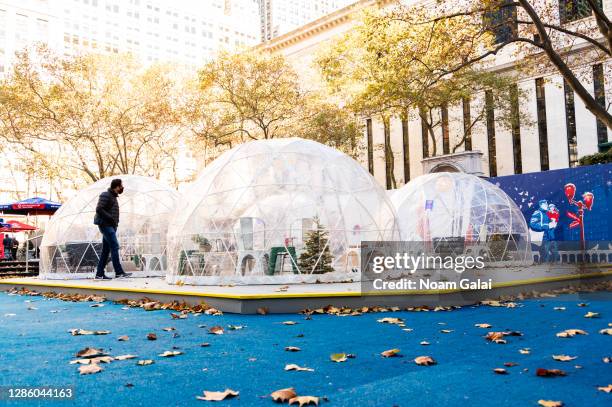 Person walks by Igloo dining tents at the Bank of America Winter Village at Bryant Park as the city continues the re-opening efforts following...
