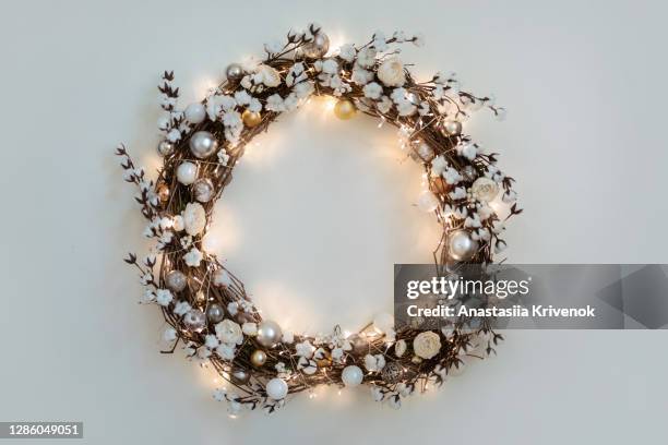 beautiful christmas wreath with burning garland hanging on the white wall. - wreath ストックフォトと画像