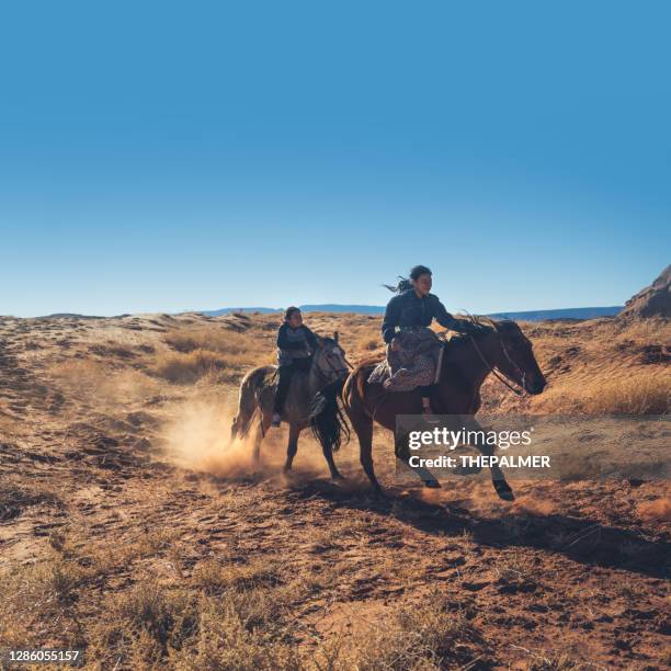 navajo broer en zus rijden op paarden in monument valley arizona - usa - desert dog stockfoto's en -beelden