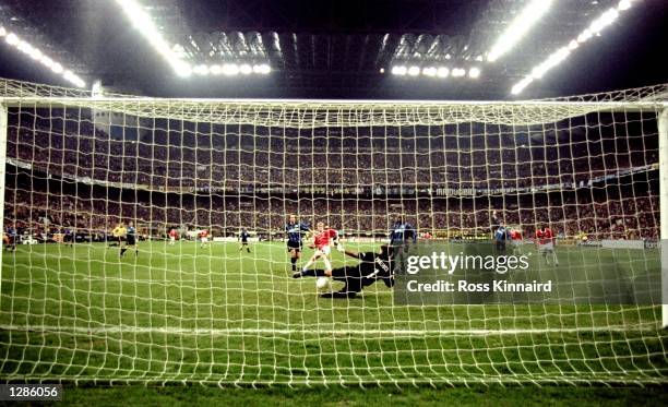 Paul Scholes of Manchester United slots the ball past a diving Gianluca Pagliuca of Inter Milan to score the equaliser in the UEFA Champions League...