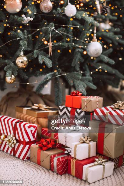 stack of christmas presents for big family under christmas tree - christmas presents under tree stock pictures, royalty-free photos & images